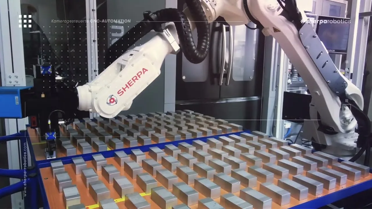 Standbild aus dem Video: SHERPA-Roboterarm über einer Palette mit Rohteilen vor einem Bearbeitungszentrum